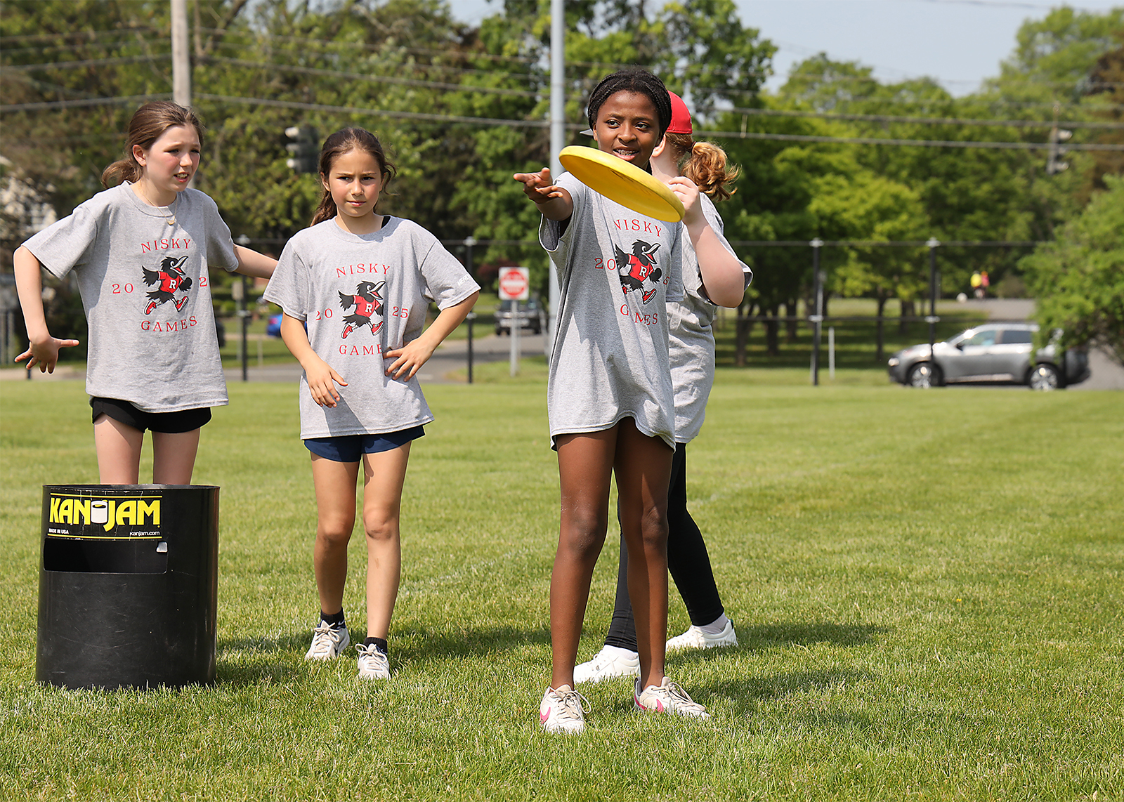 elementary students throwing a frisbee on field day
