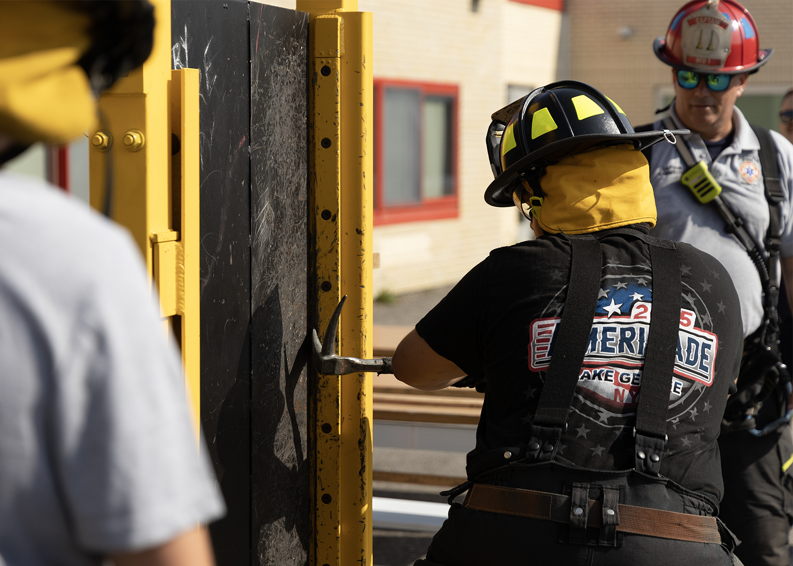 student in fire fear breaks down a door during summer enrichment fire and safety drill