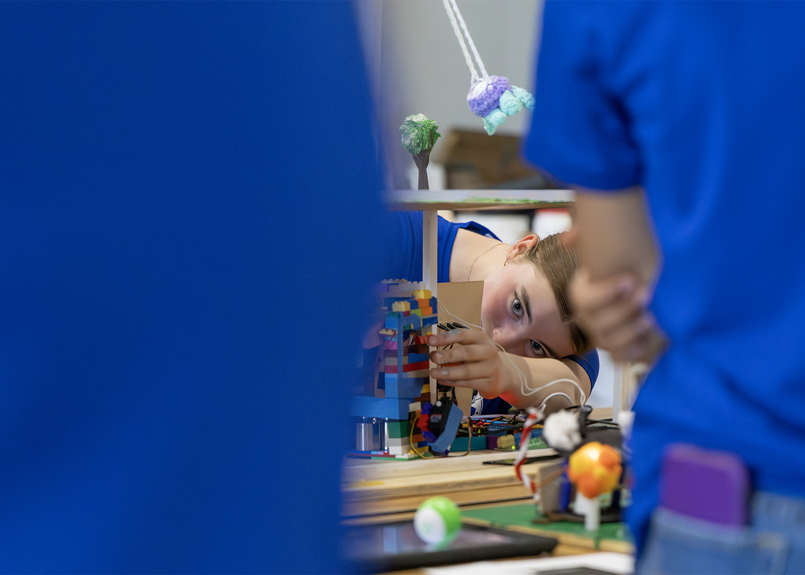 STEM camp student adjusting LEGO brick project