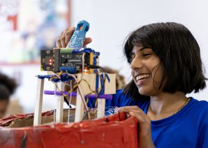 STEM camp student smiling with hot glue gun