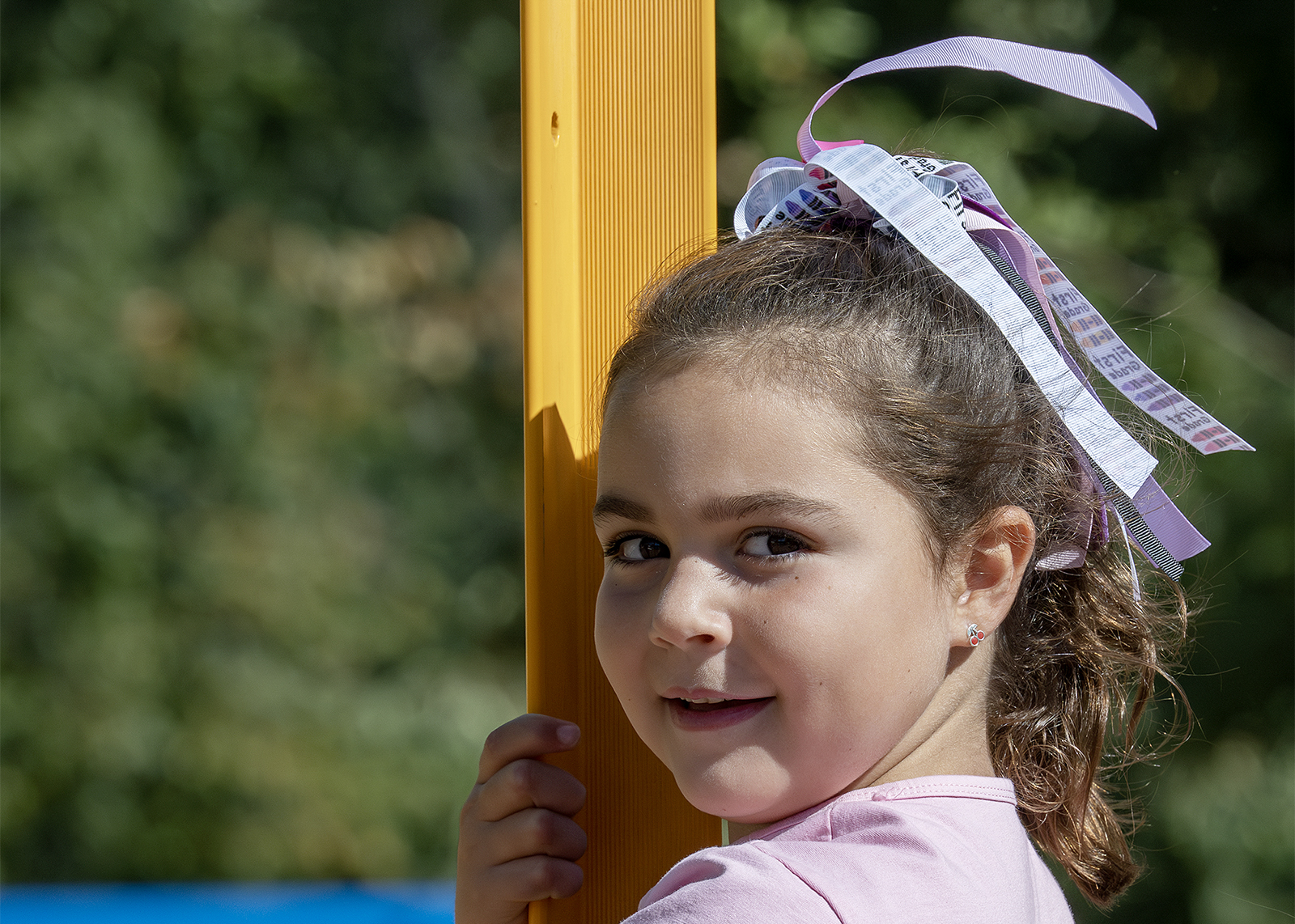 student wearing a bow smiling