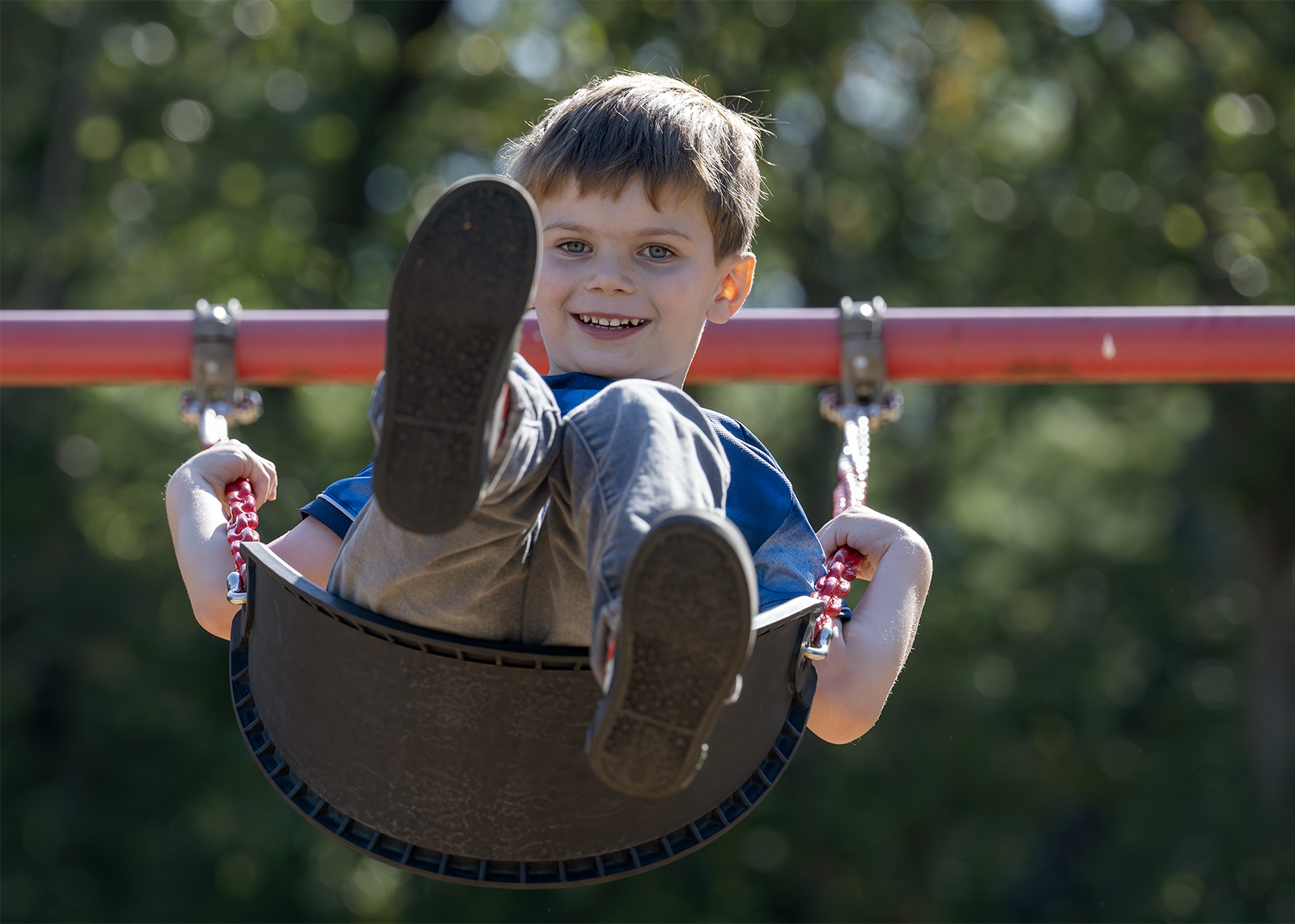 student swinging and smiling