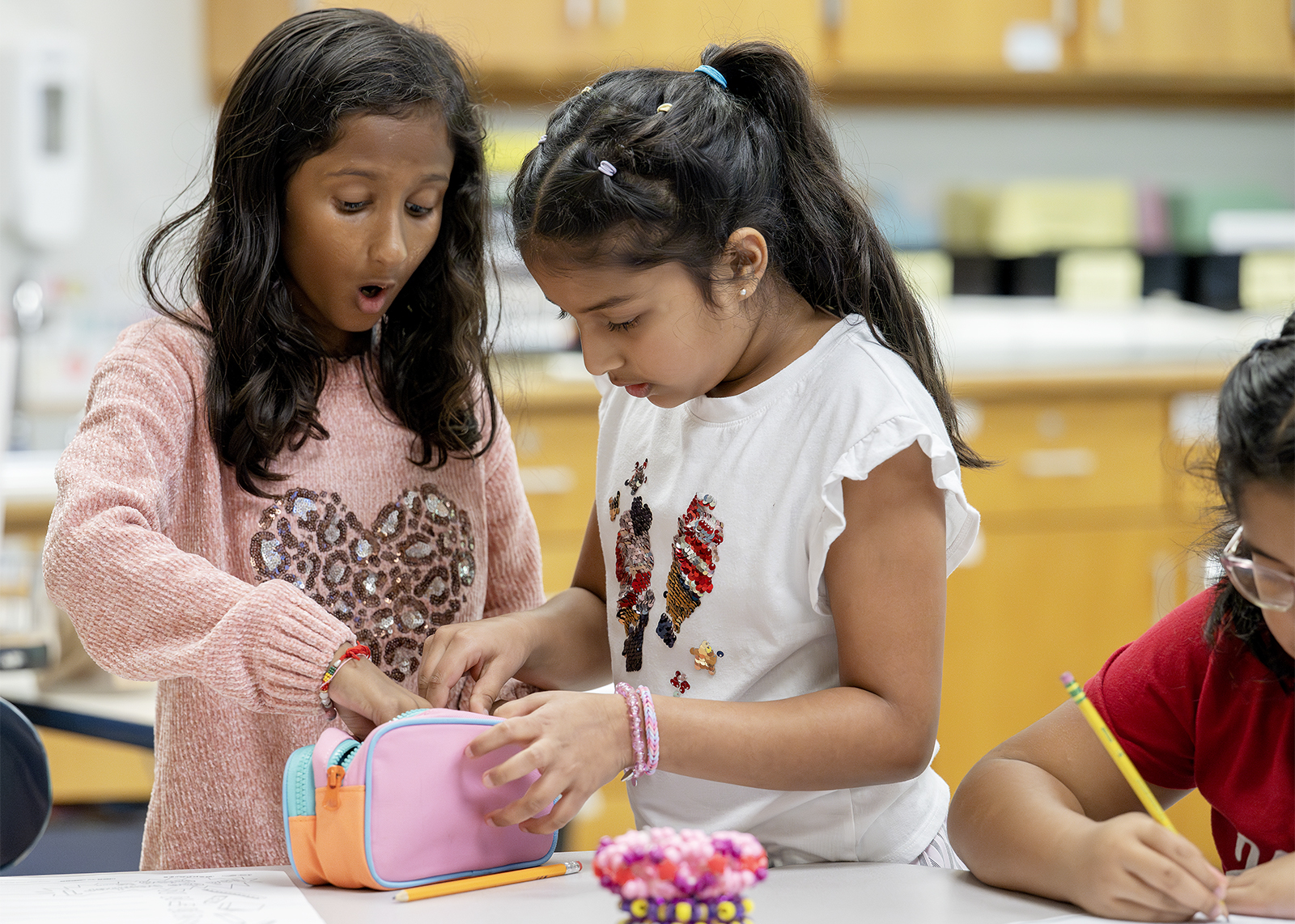 two students looking in pencil case with surprise