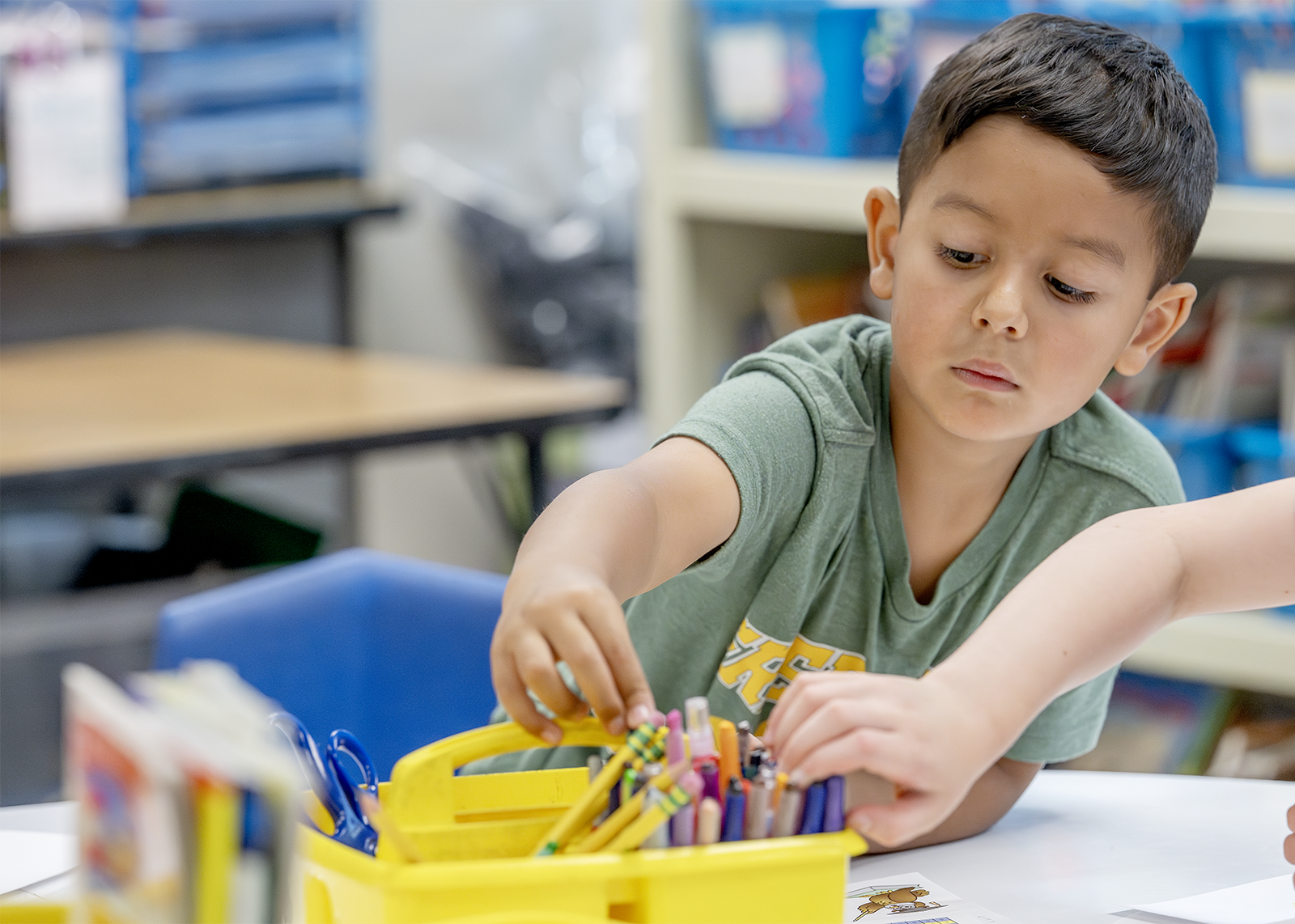 elementary student reaching for crayons