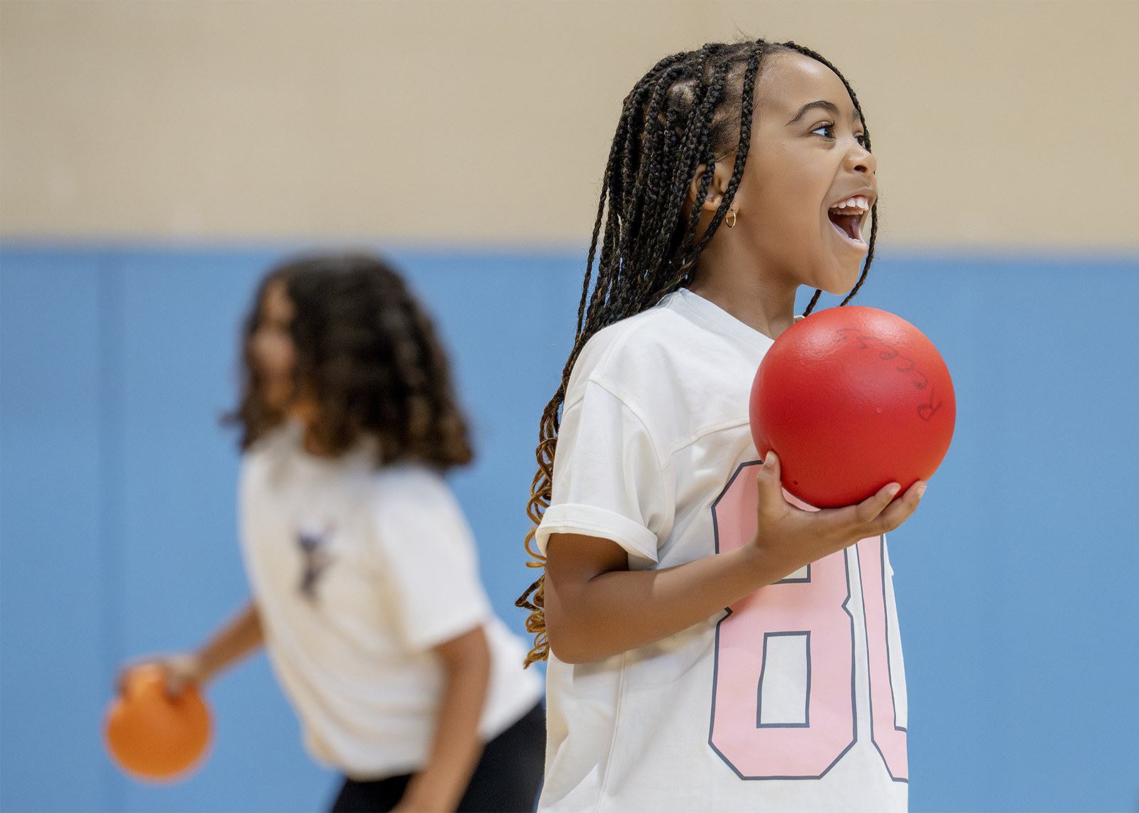 elementary student smiling while playing dodgeball