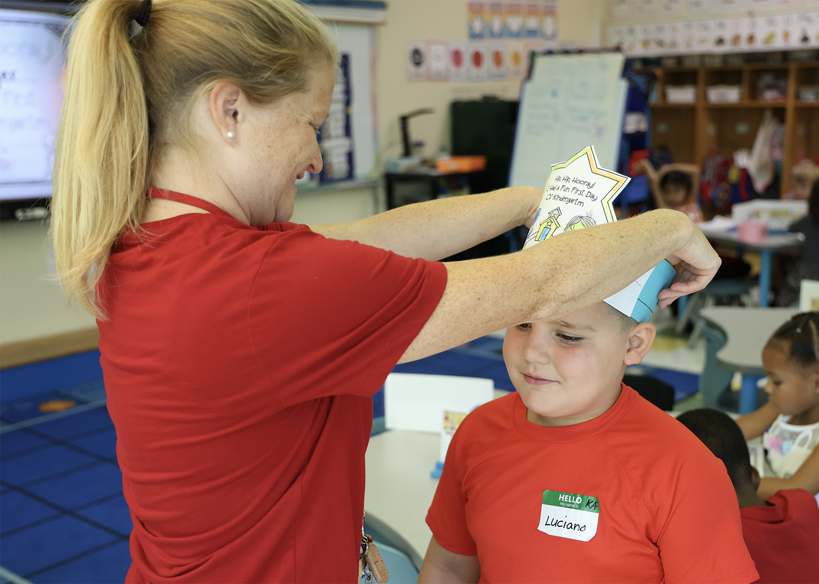 k teacher places crown on student