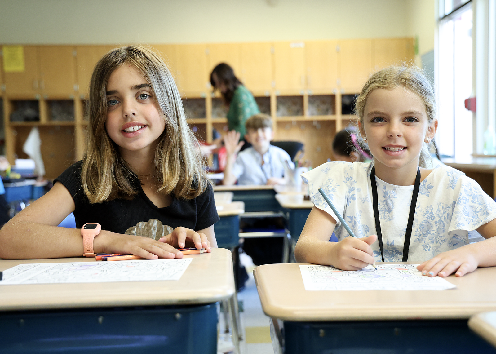 two friends smile in class
