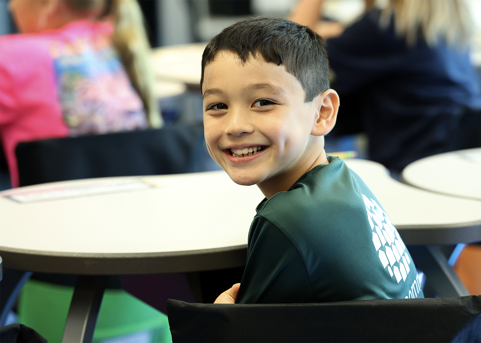 student smiles while looking over shoulder in class