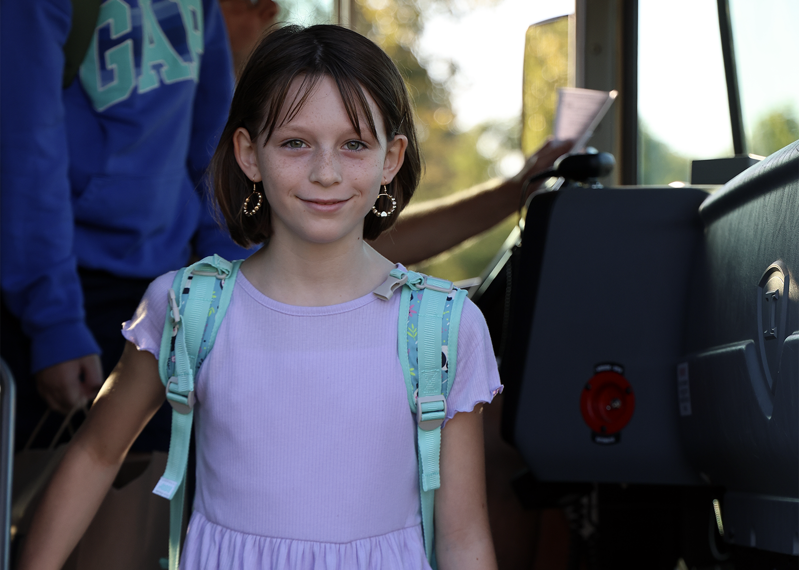 girl smiles while getting off the bus