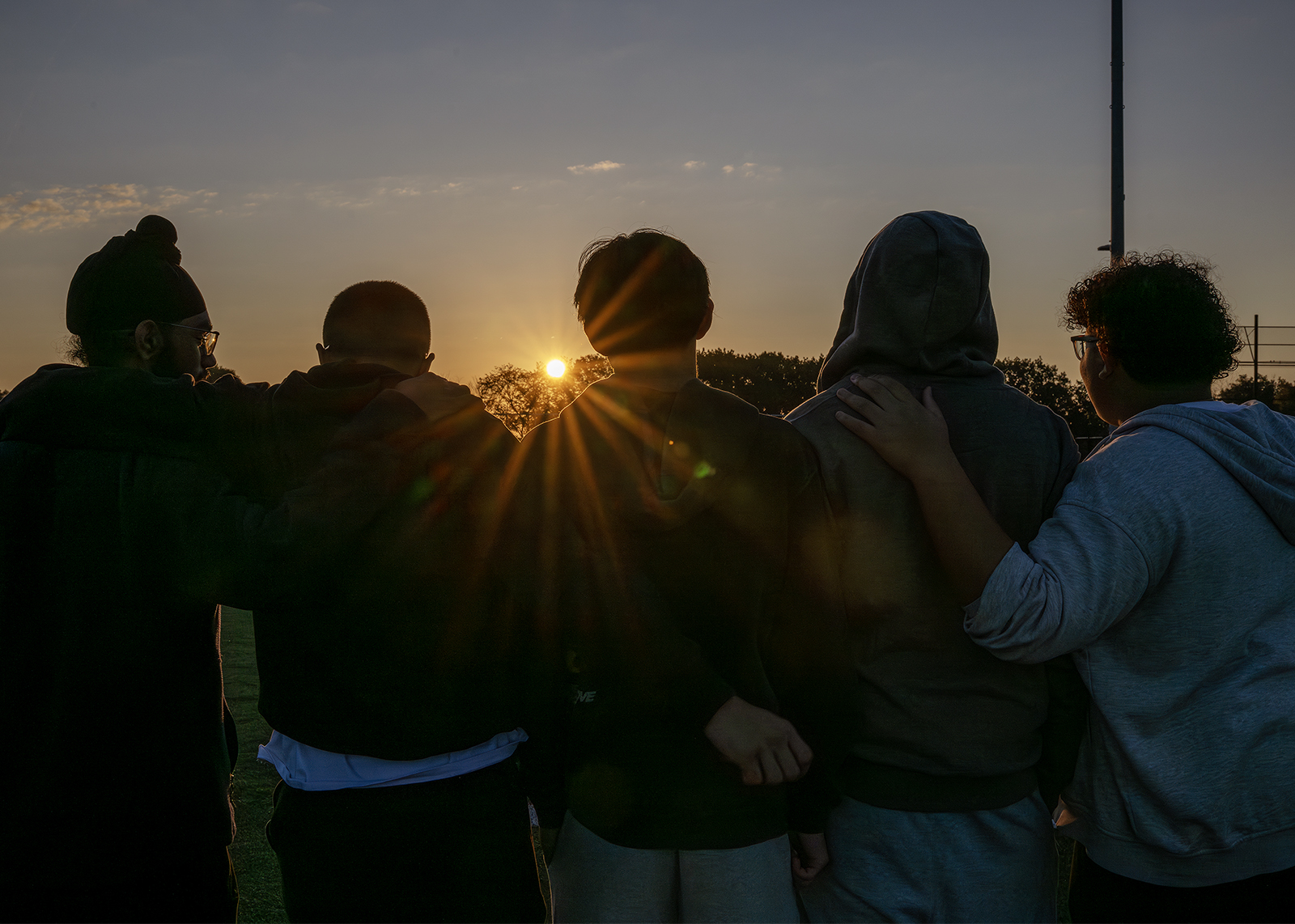 silhouettes of students as they enjoy senior sunrise