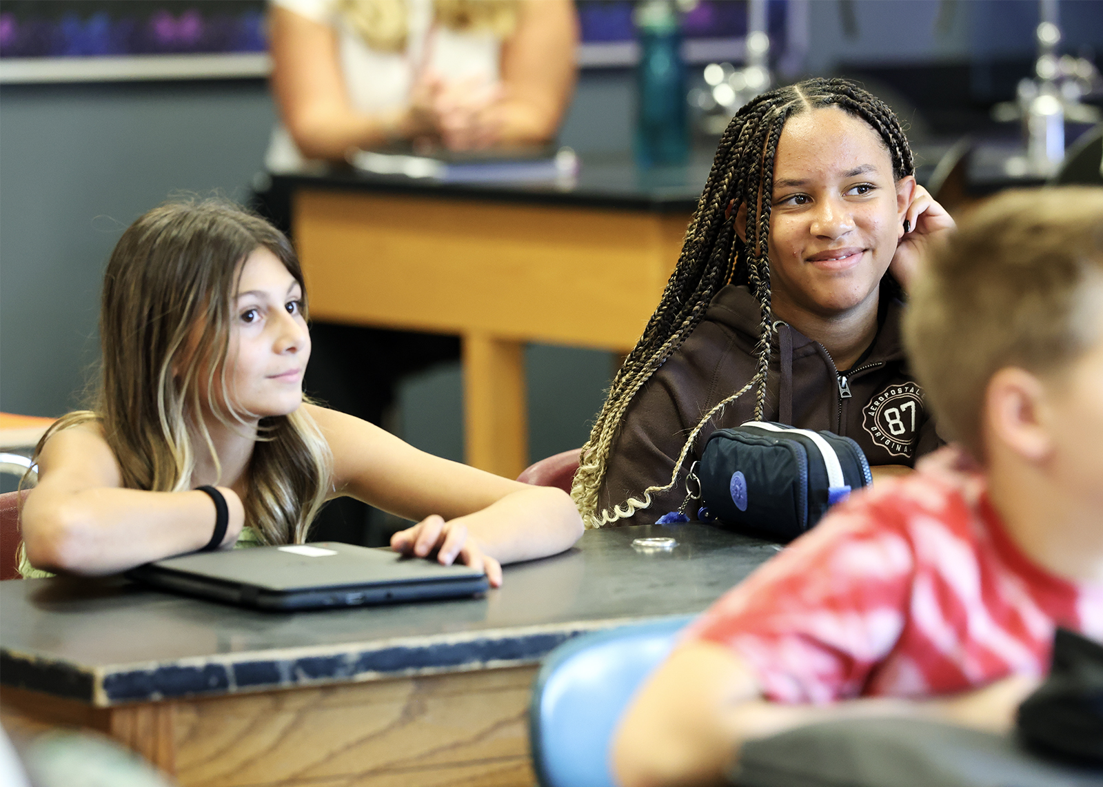 middle school students at desks smiling