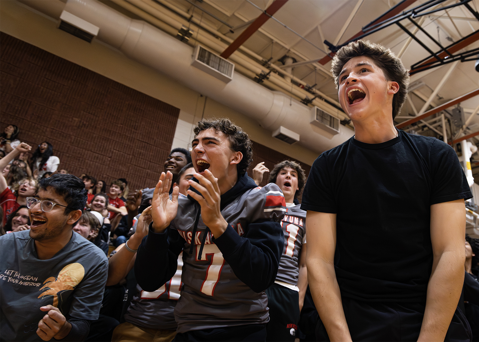 low angle shot of students yelling at pep rally