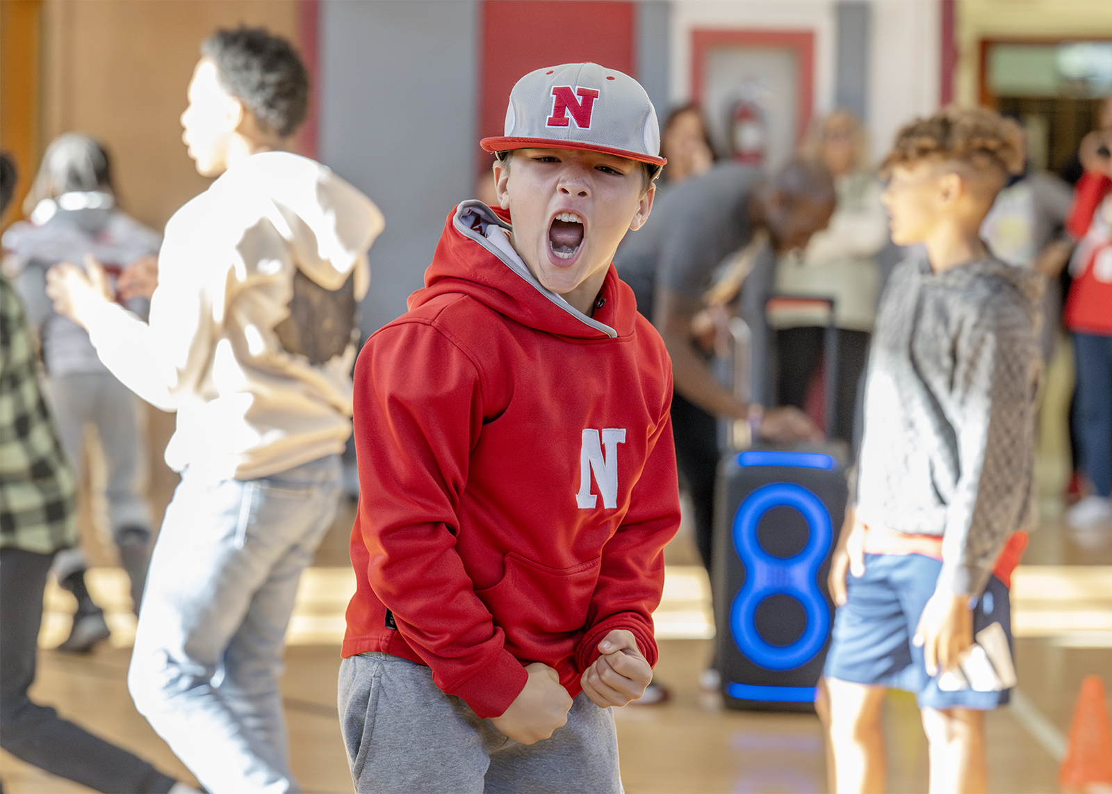 student in gynamsium cheering while looking at camera