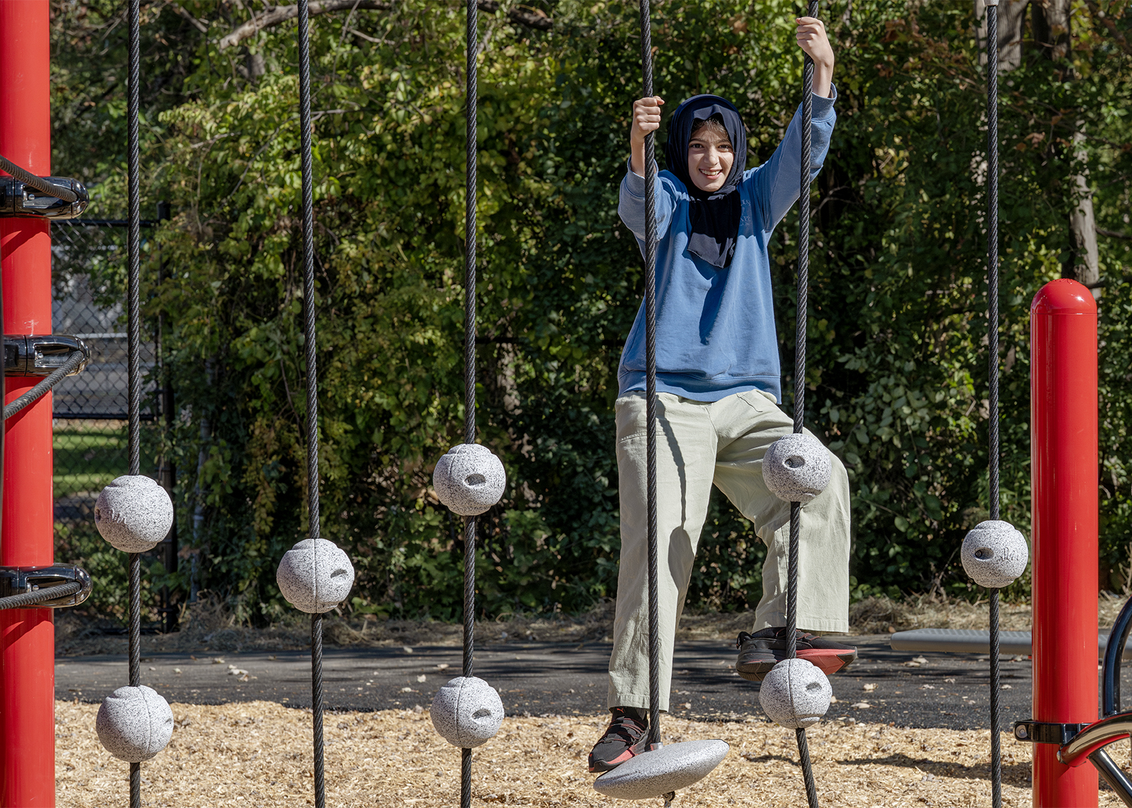 sixth grader smiles on new playground ropes