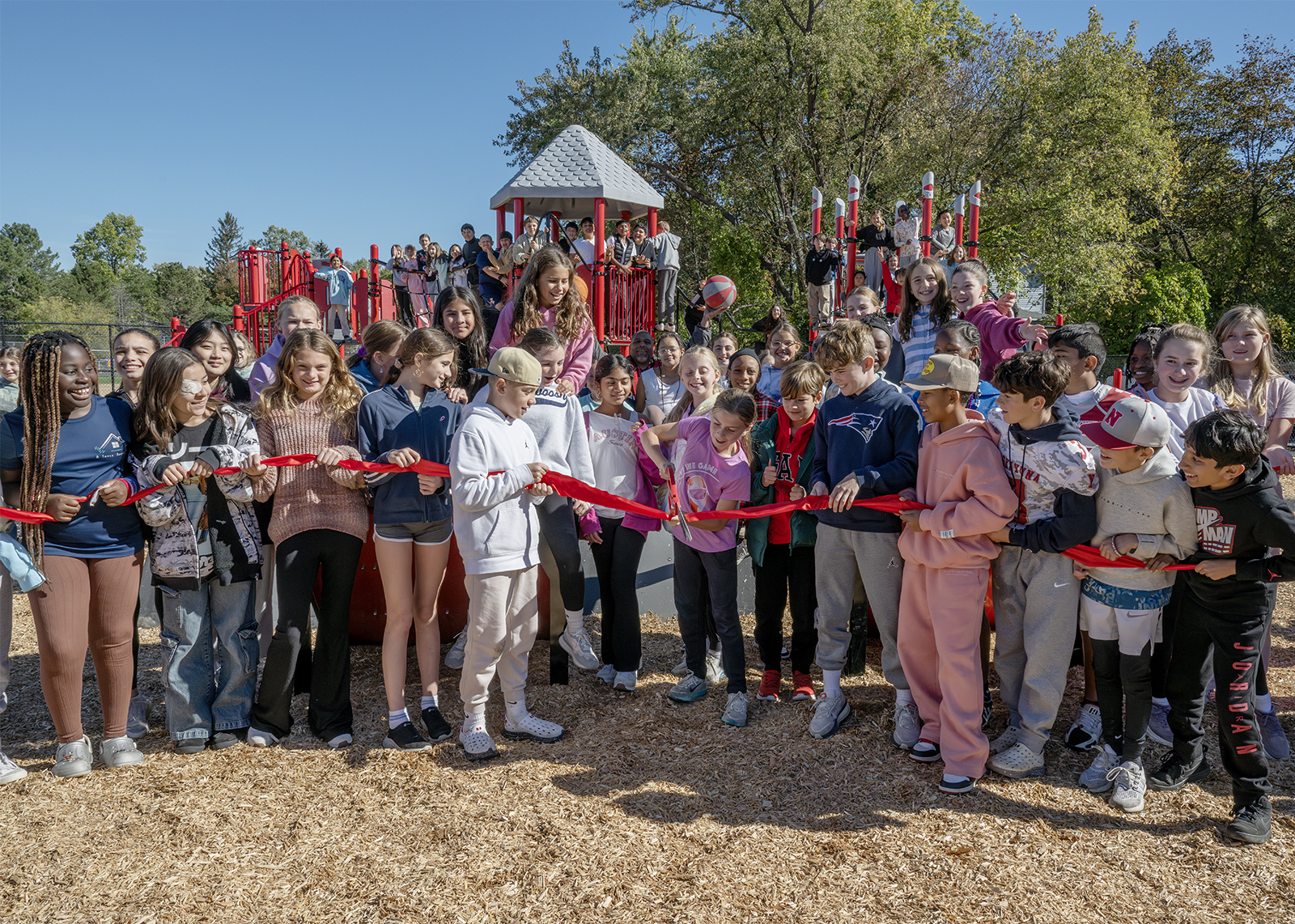 group of sixth graders cutting the ribbon on a brand new play space