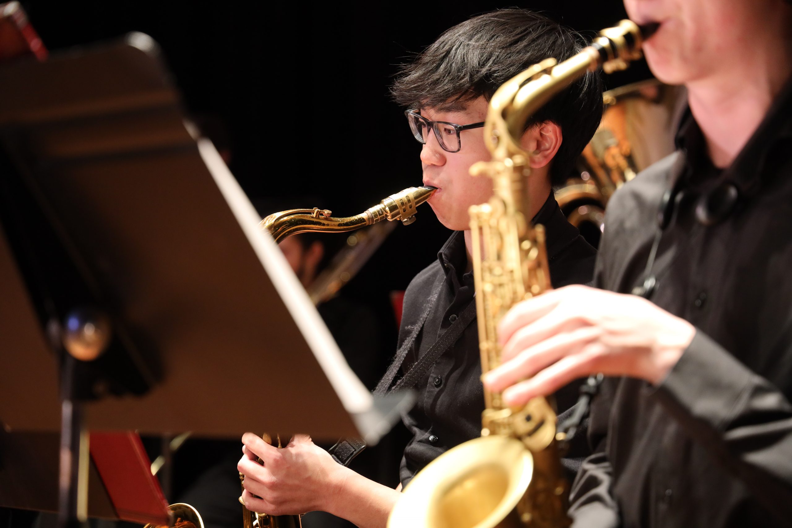 Student plays saxophone during performance.
