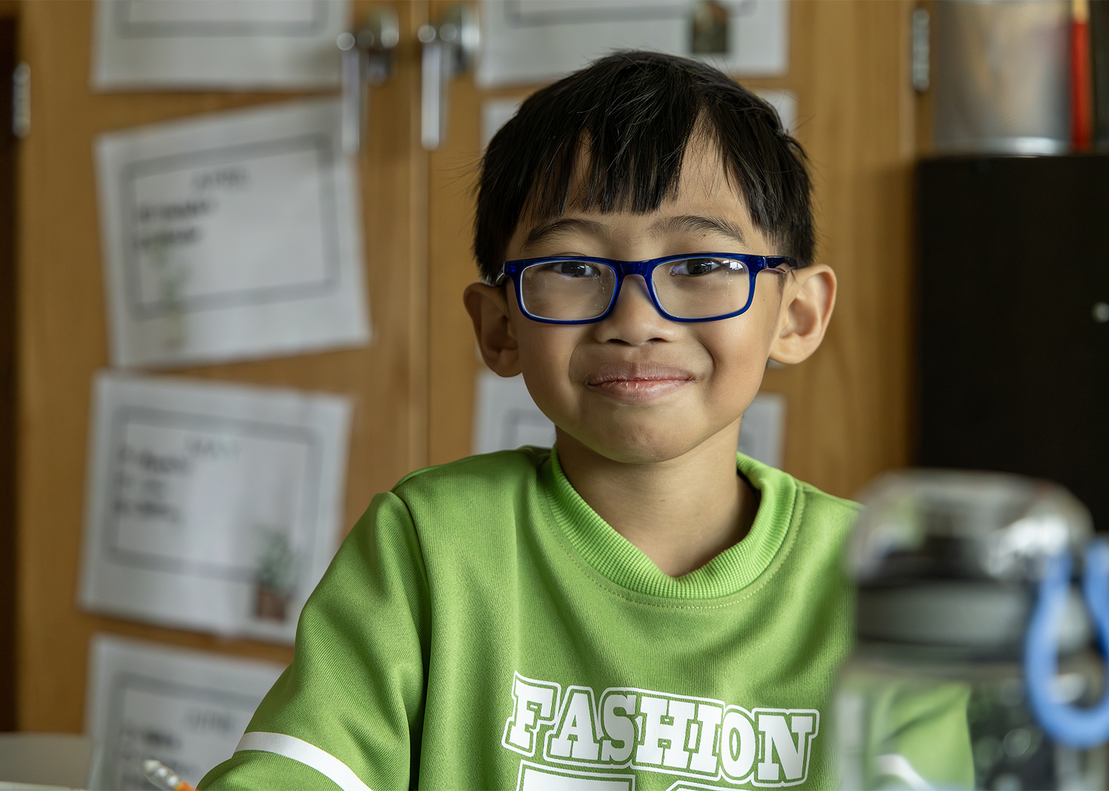 second grade student wearing glasses smiling at the camera