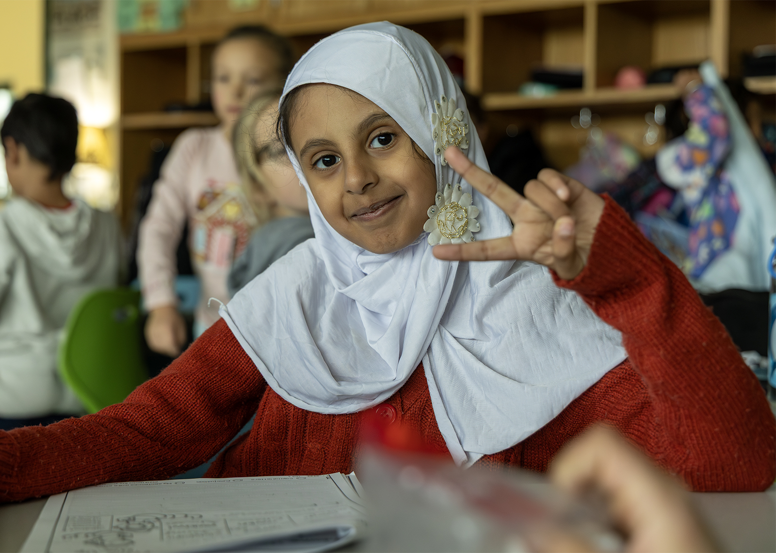 second grade student giving a peace sign at the camera