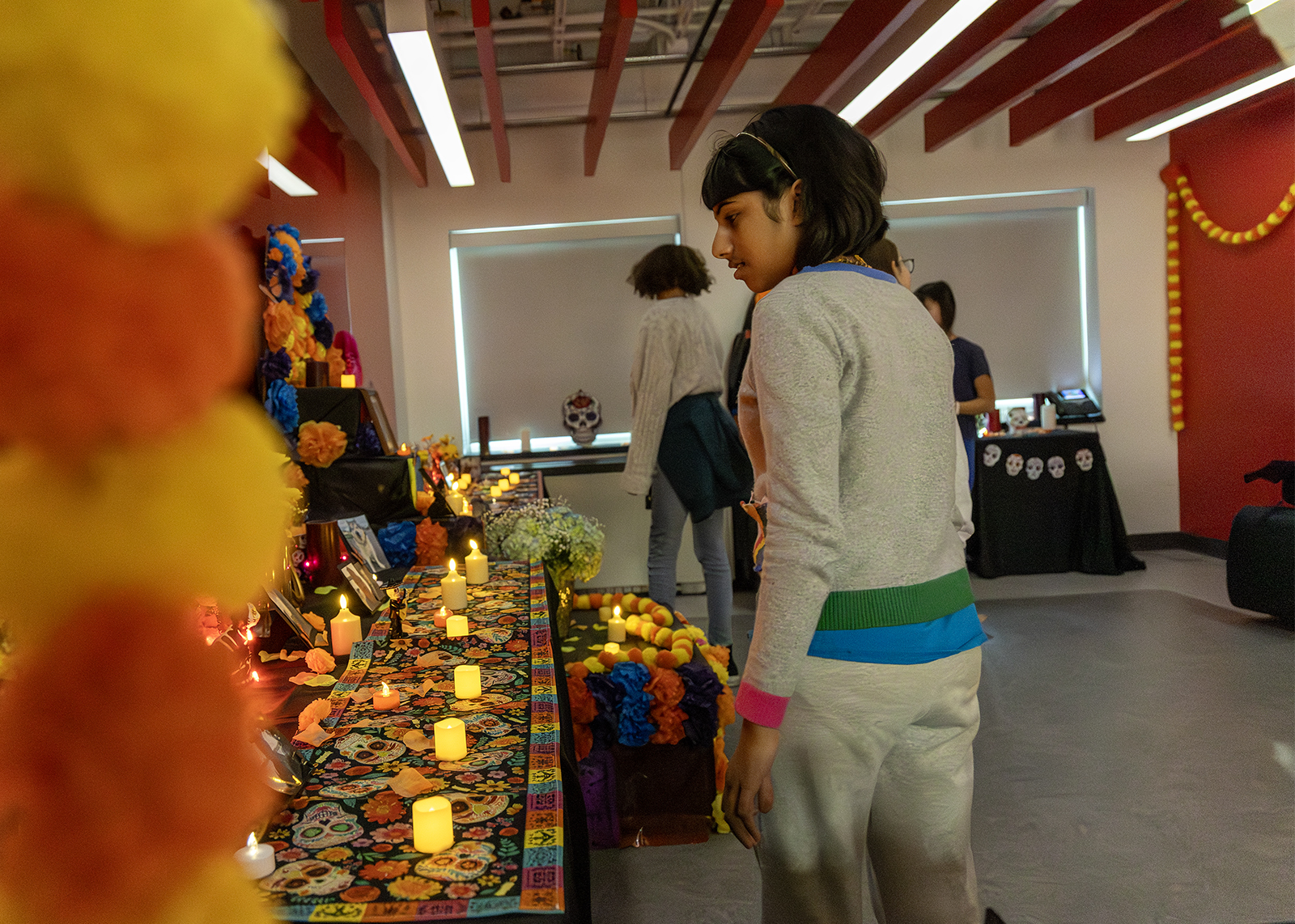 student looking at the ofrenda for dias de los muertos
