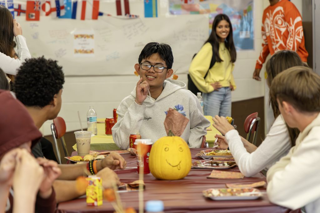 Niskayuna English as a new language students sit at a table together celebrating Thanksgiving