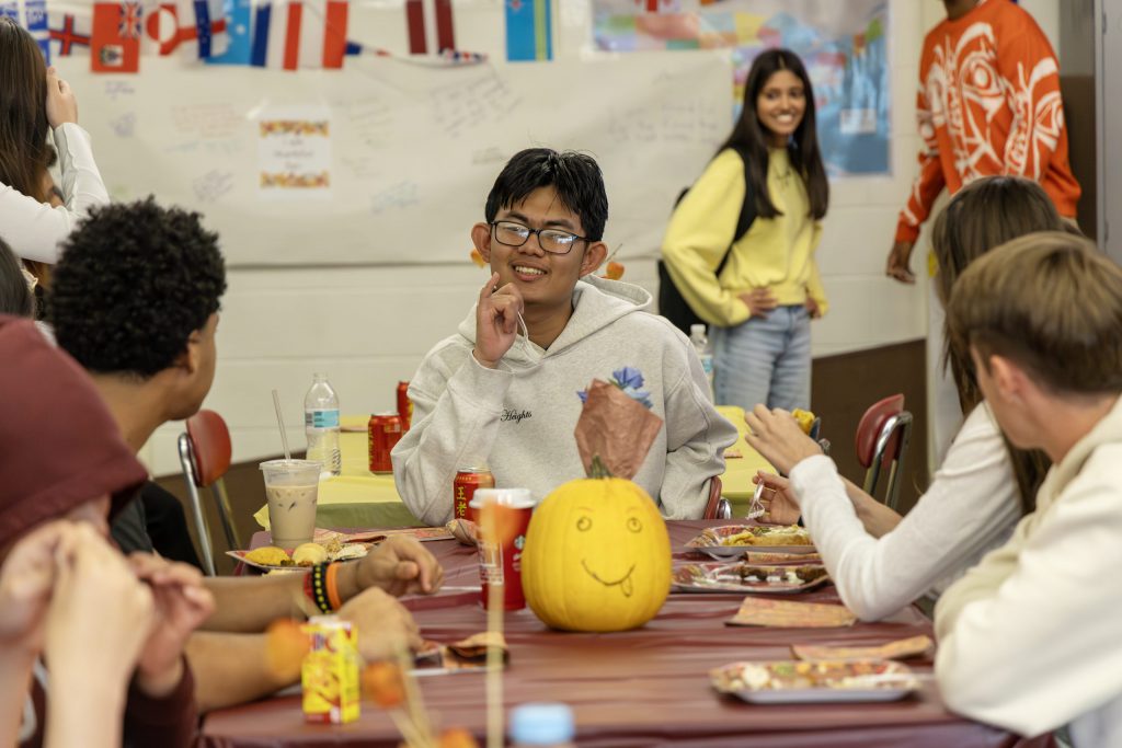 Niskayuna English as a new language students sit at a table together celebrating Thanksgiving