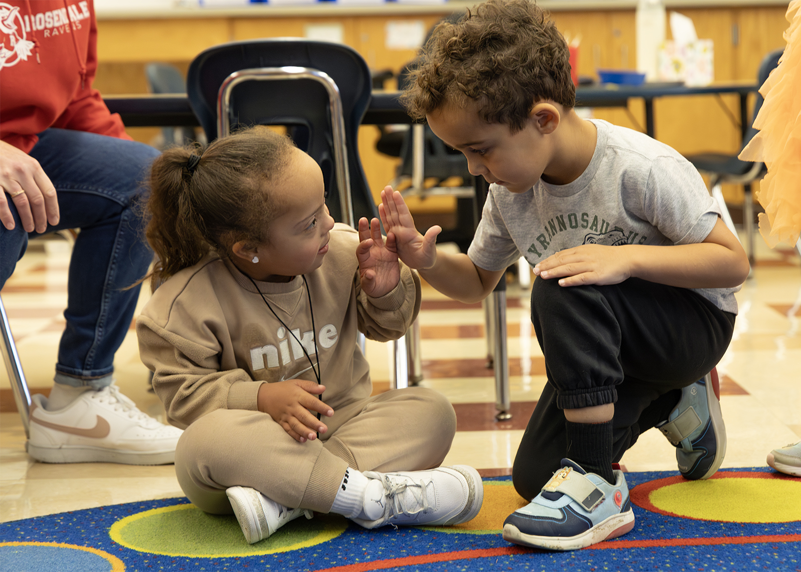 students high five in a kindergarten classroom
