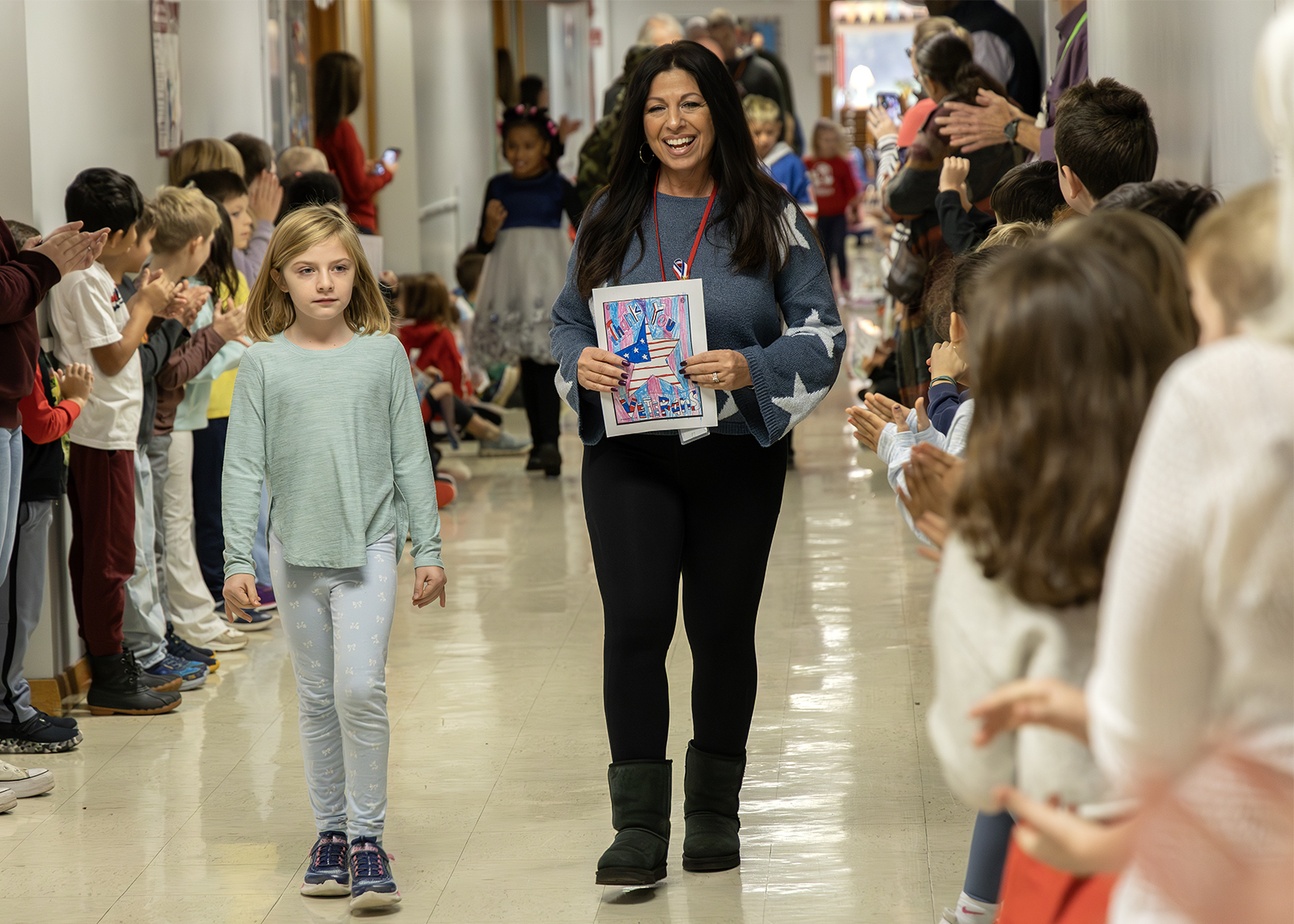 staff and student walk through halls for indoor parade