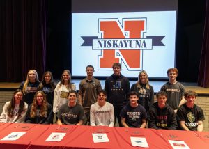 group of student-athletes smile after signing national letters of intent