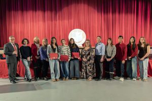 Board and student-athletes pose for group photos, three students are holding awards