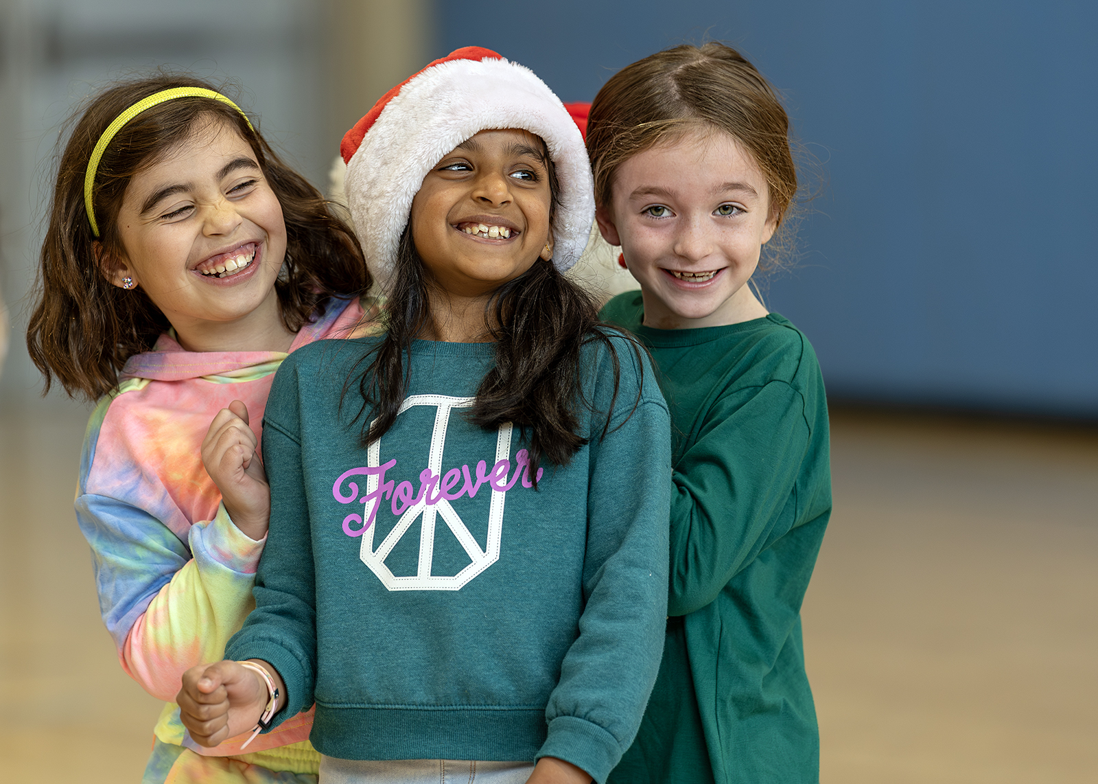 three elementary students smiling during PE class