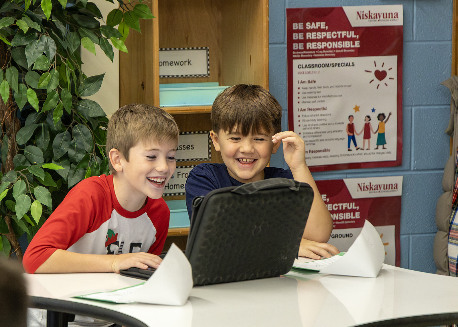 elementary students laughing at chromebook