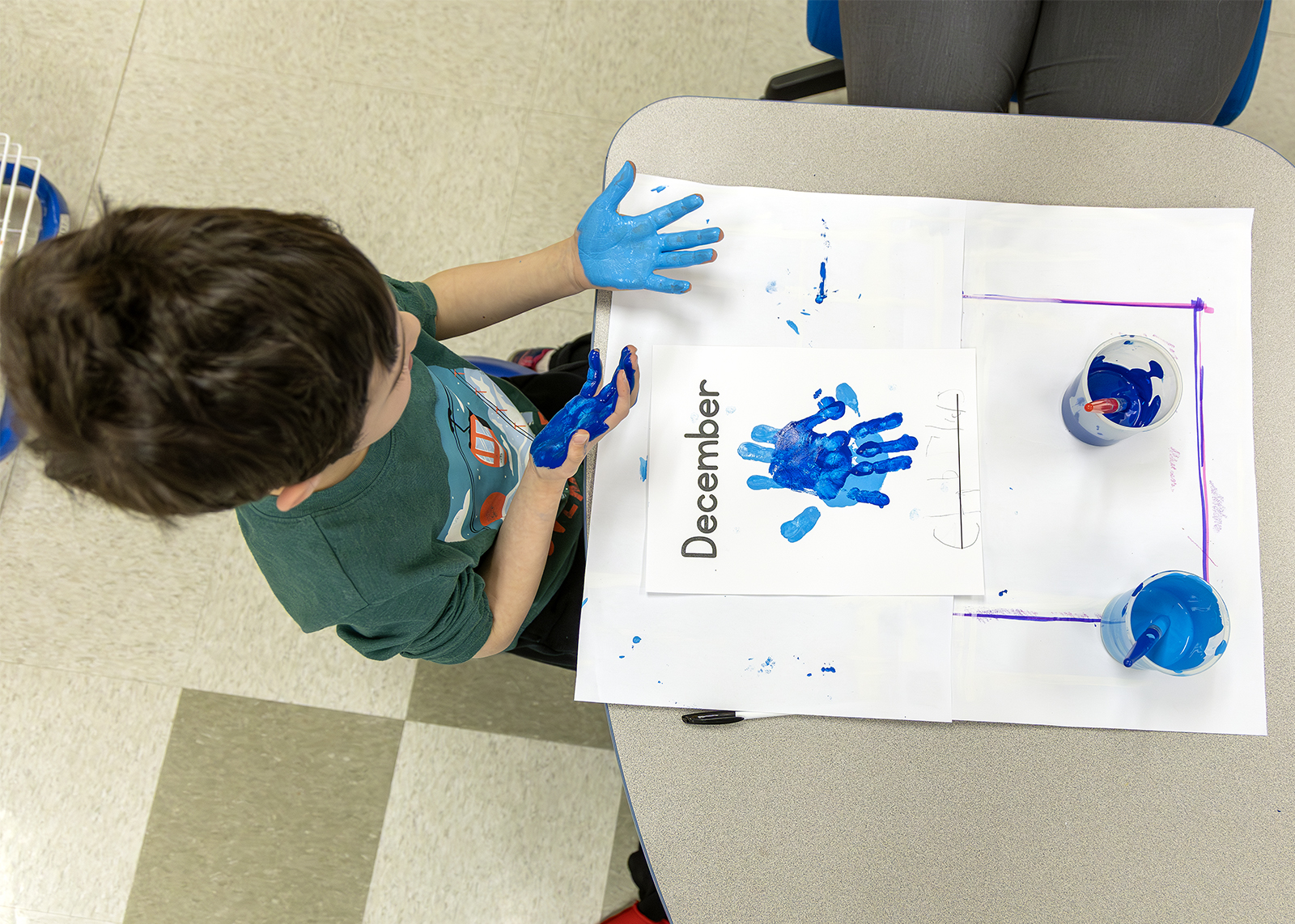 kindergartener doing finger painting
