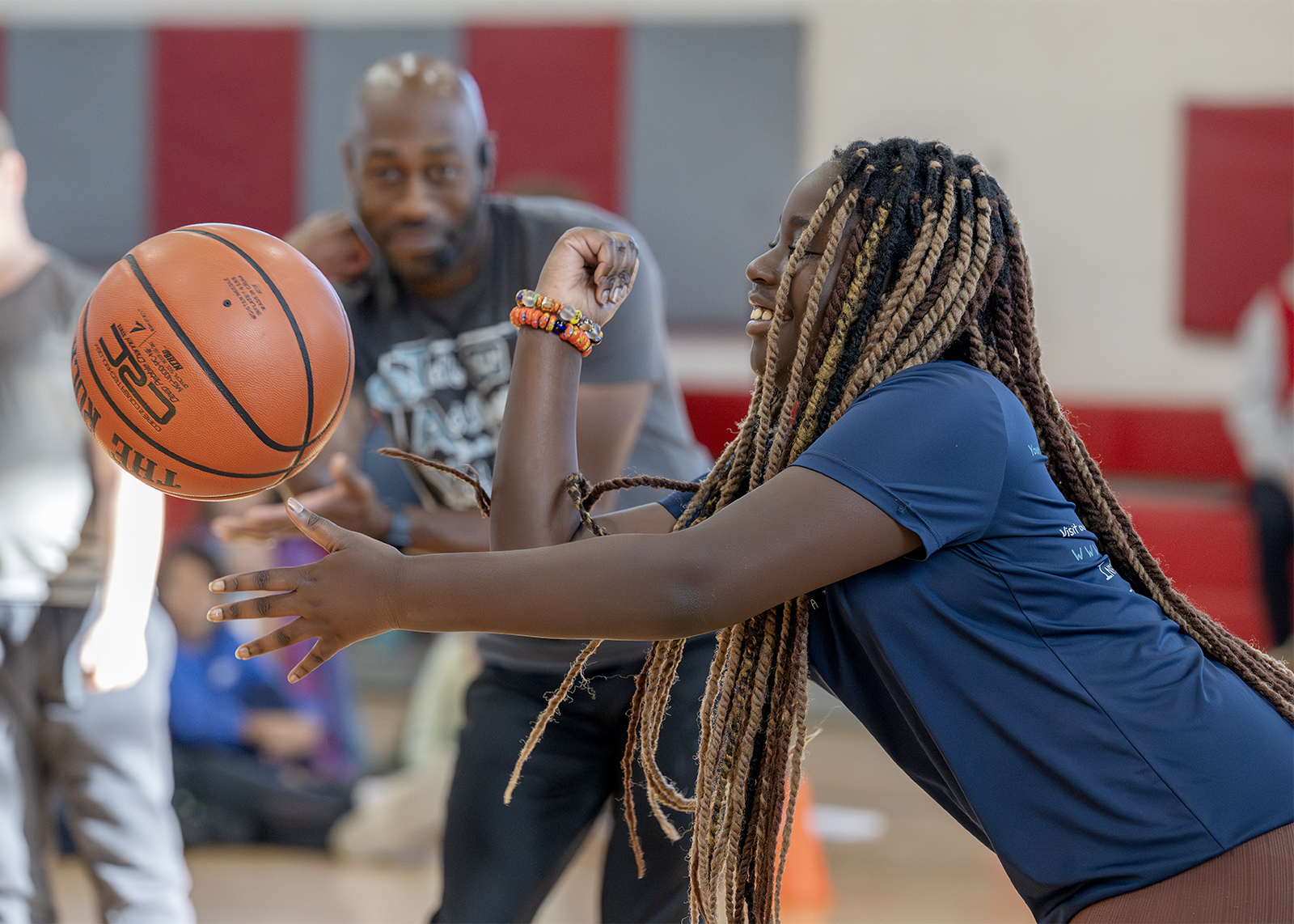 sixth grader doing basketball tricks with former harlem globetrotter