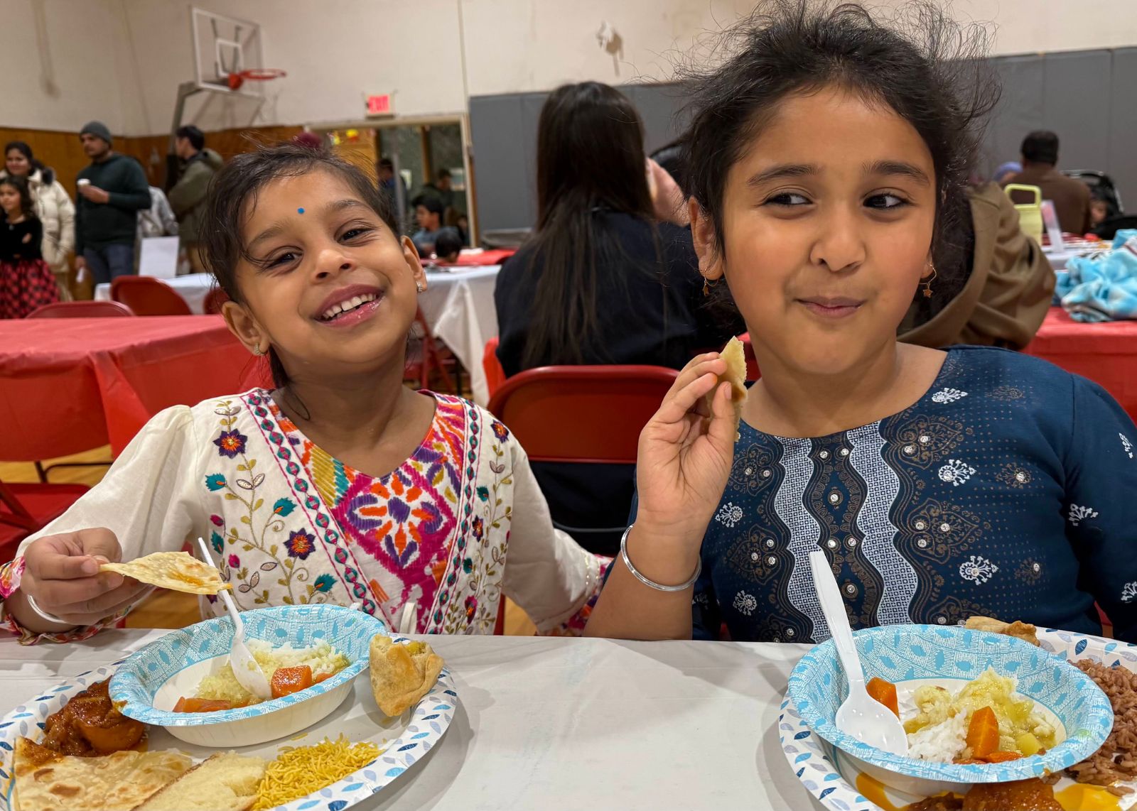 two elementary students eat foods shared from around the world