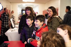 Students and families engaging with a creative career professional at an event booth