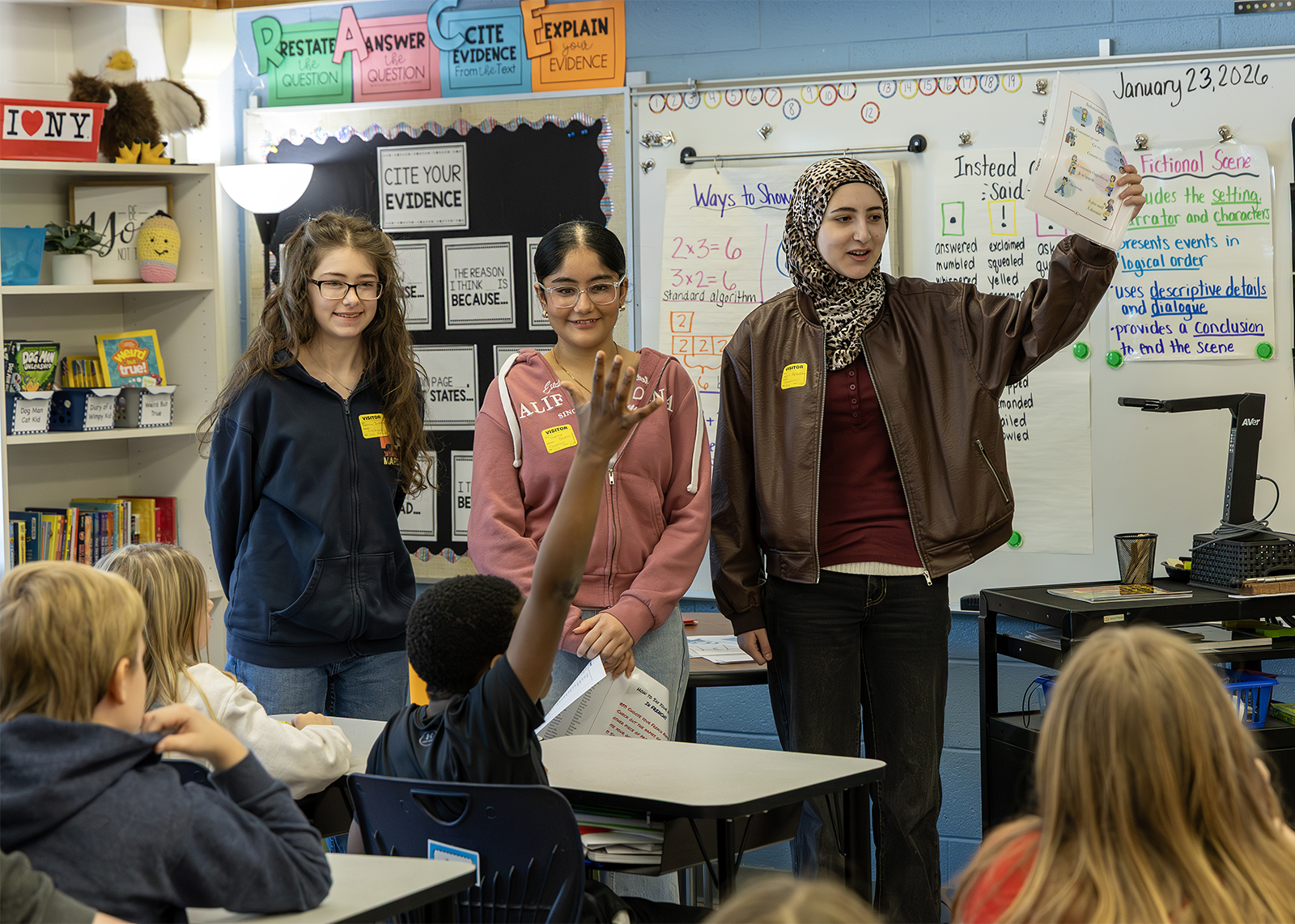high schoolers reading French Fairytales to fourth graders