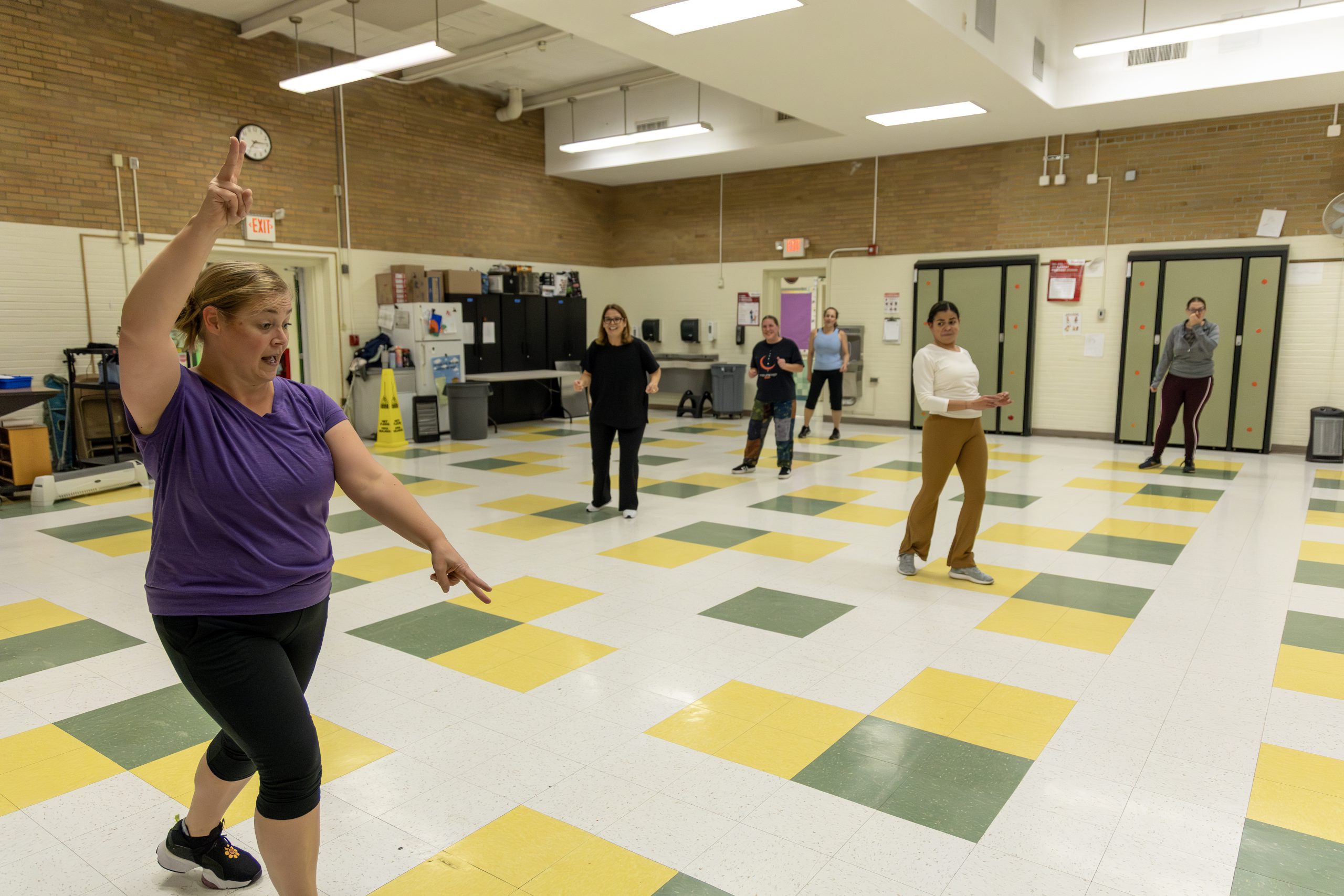 Zumba instructor leads class of continuing education students in classroom.