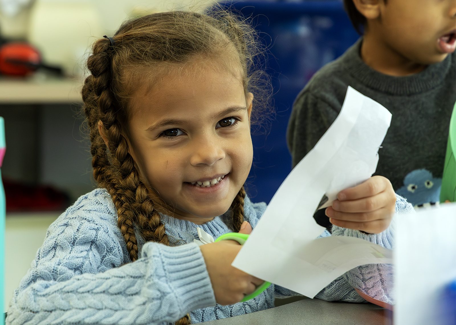kindergarten student using scissors for a project