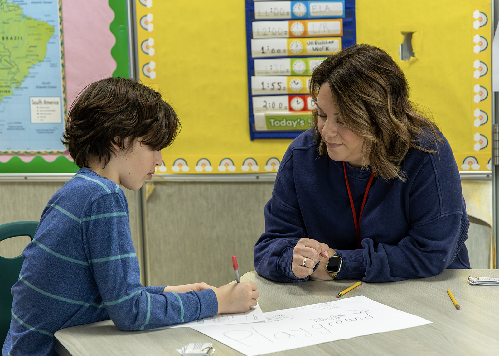 teaching assistant works with student at elementary school