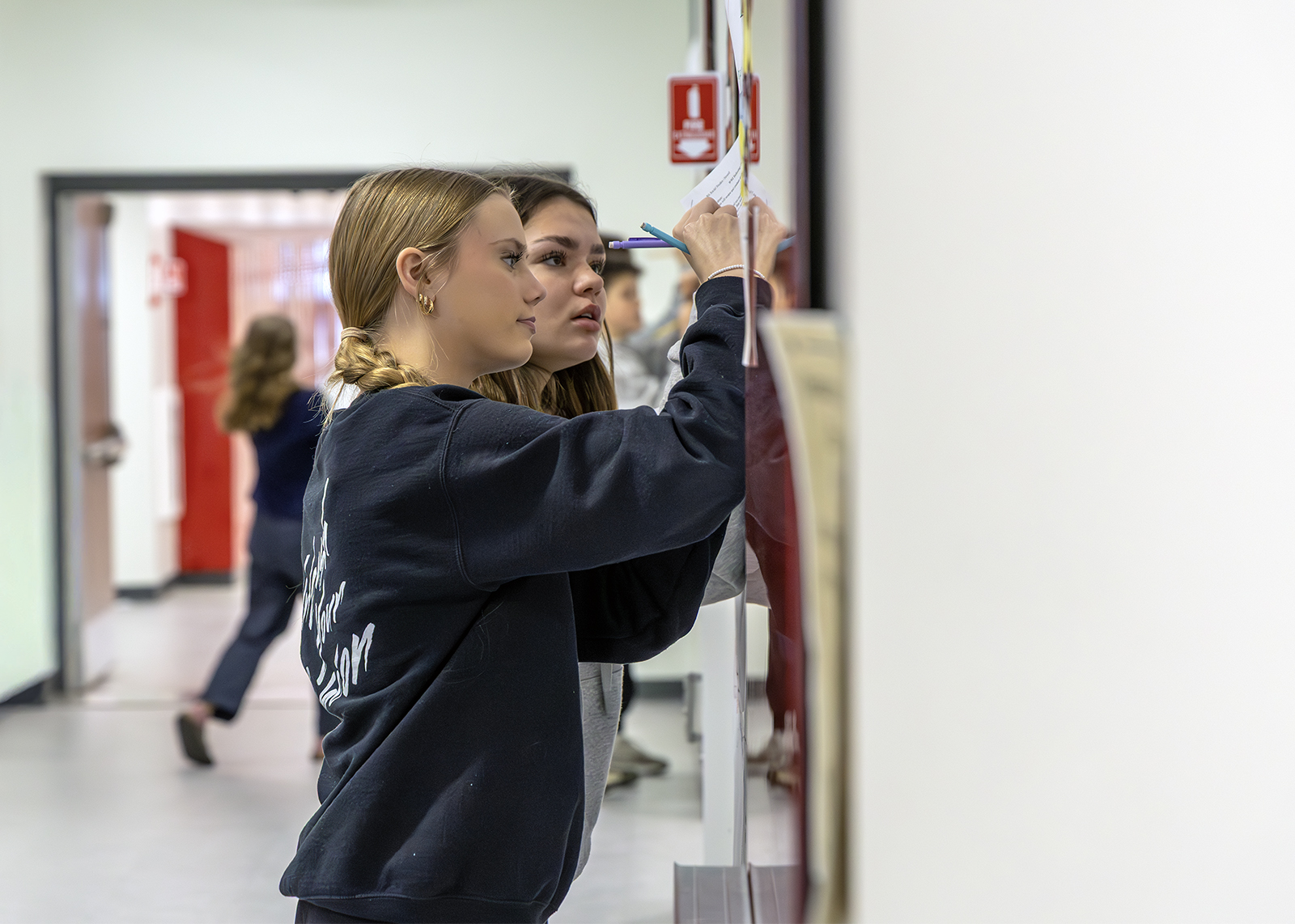middle school students doing a project in the hall