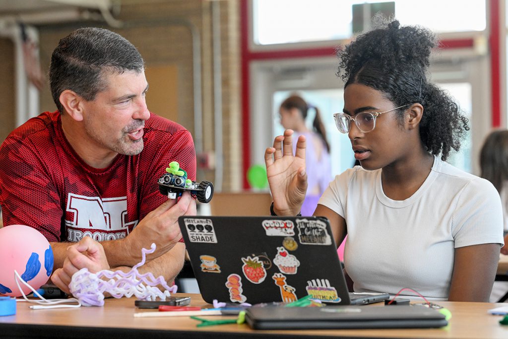 Teacher and student discuss engineering project.