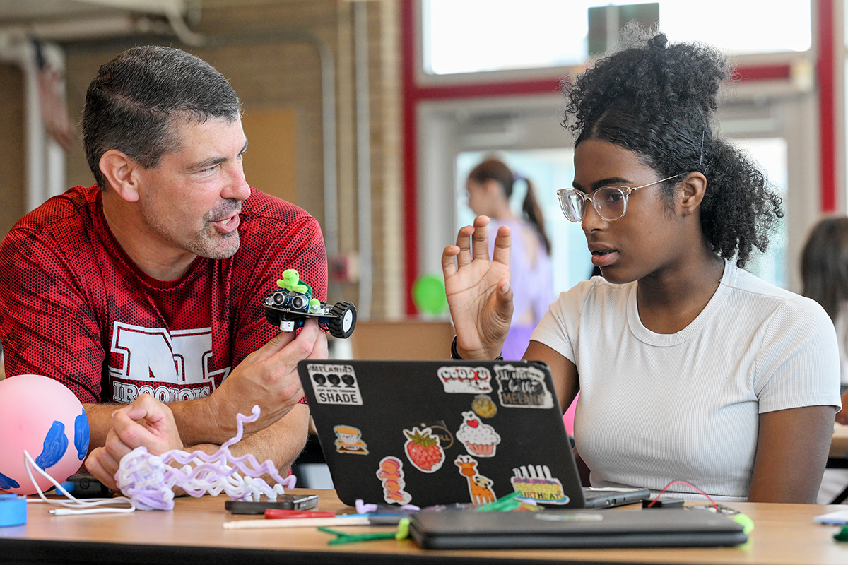 Teacher and student discuss engineering project.