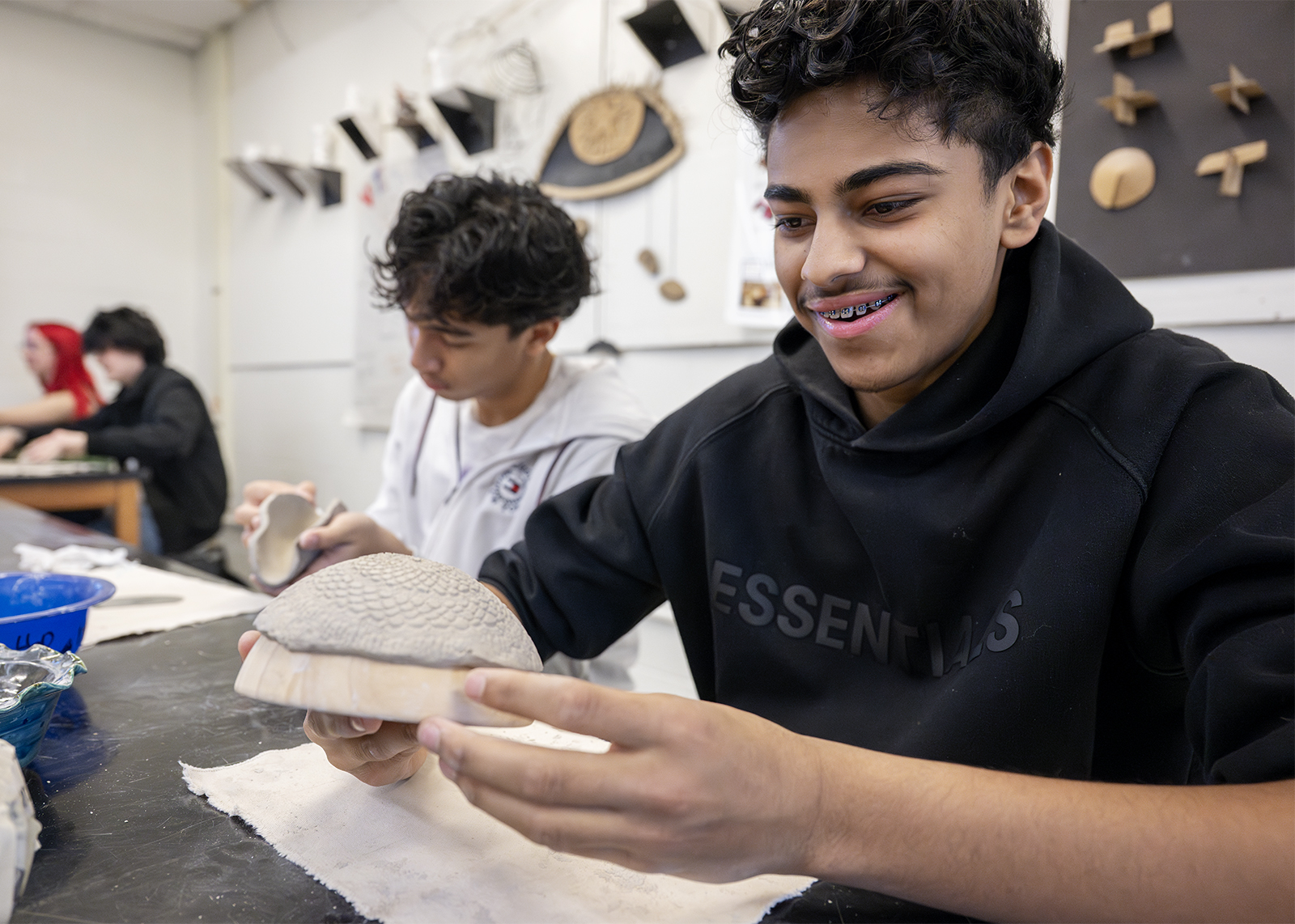 high school student smiling with pottery project