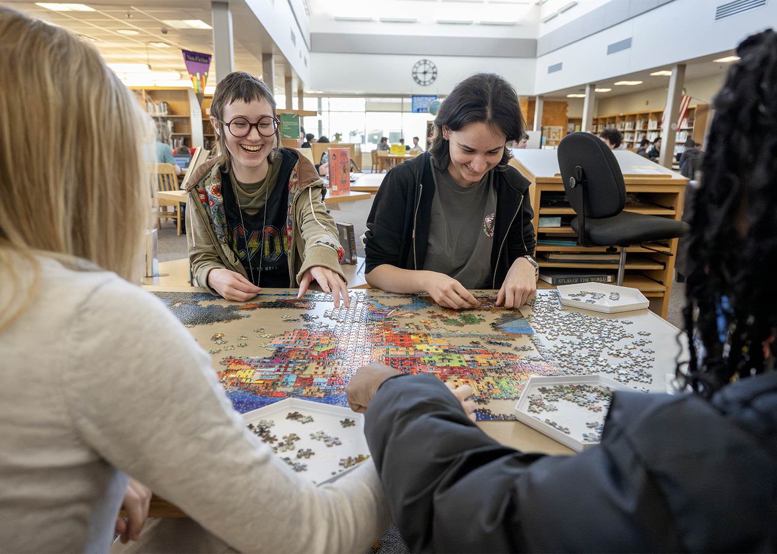 high school students in library working on puzzle