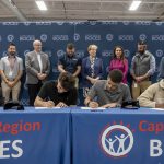Two students holding CTE signing day certificates at a ceremony table