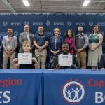 Two students holding CTE signing day certificates at a ceremony table