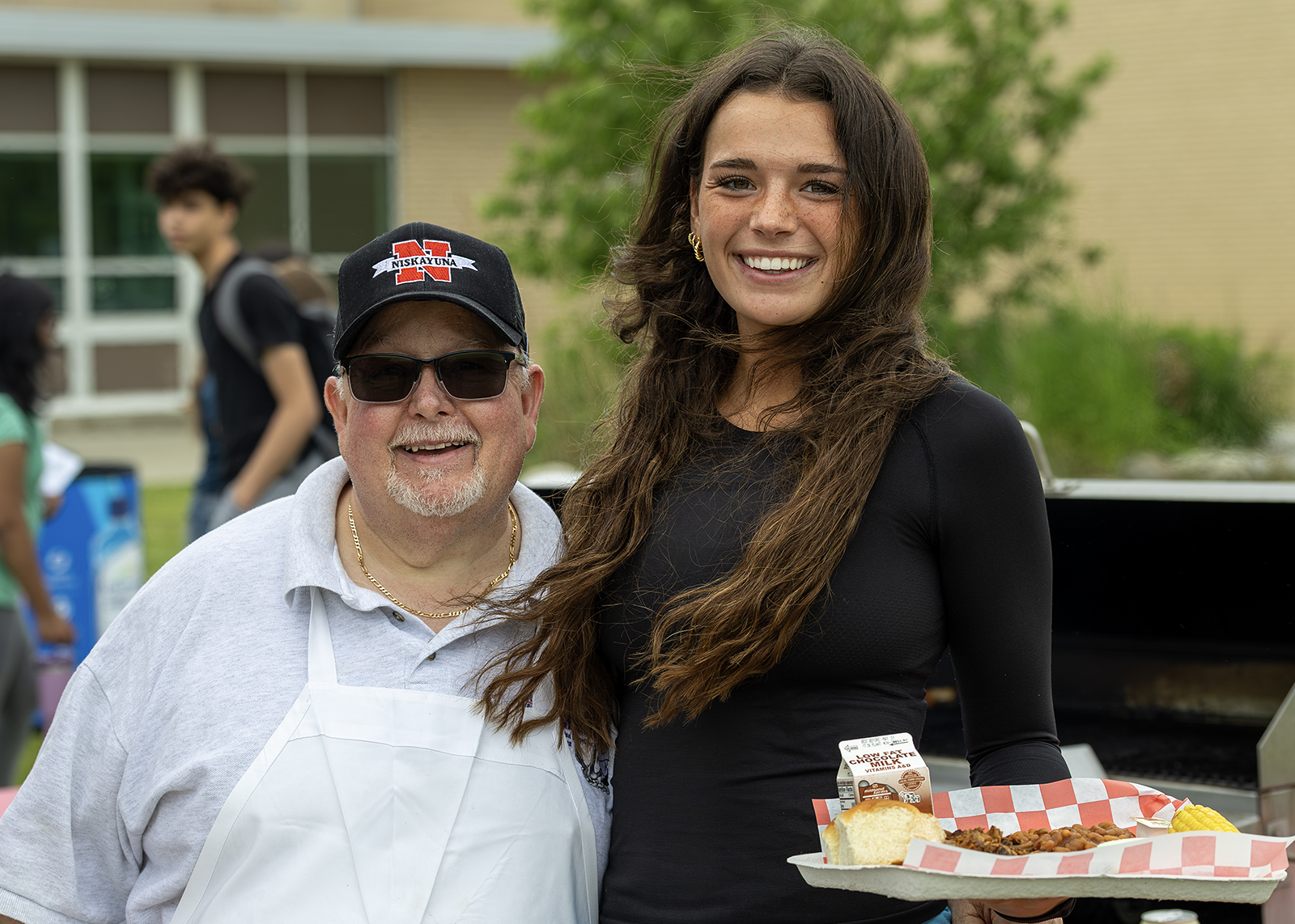 high school student smiles with cafeteria manager bob