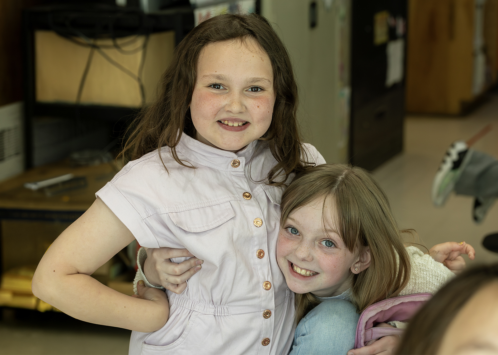 two elementary students smiling for camera in the cafeteria