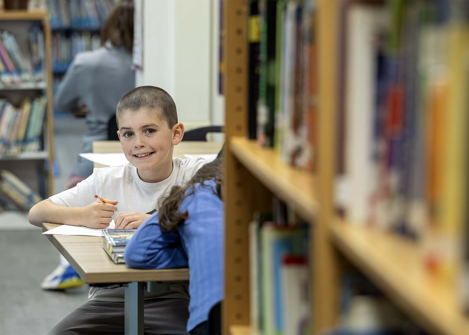elementary student in library smiling at camera