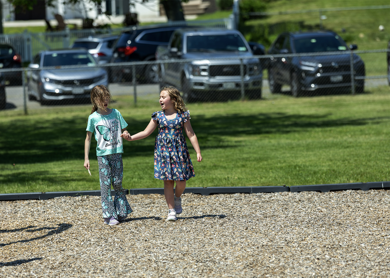 two elementary students on the playground holding hands